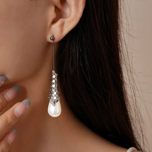 Detail of 18k gold plated earring showing sequin hexagonal links and a teardrop pearl