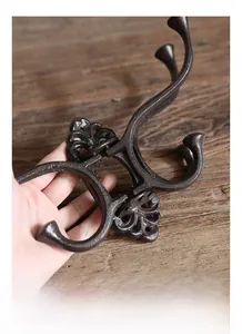 Detail of vintage cast iron multi-hook with intricate floral patterns and matte finish