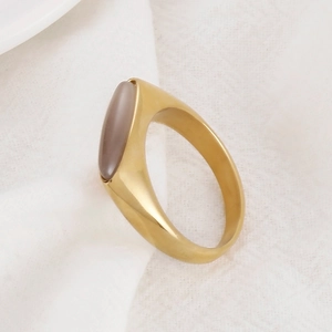 Detail of a gold mesh-style stainless steel ring set with a grey oval gemstone cabochon
