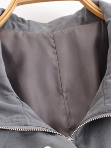 Detail of dark grey jacket featuring smooth satin lining and premium metal zipper closure