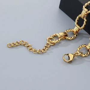 Detail shot of golden twisted rope links and smooth oval rings with a lobster clasp closure