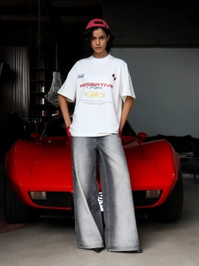 Streetstyle λευκό υπερμεγέθες t-shirt με τύπωμα αγώνων και γκρι τζιν με κόκκινο αμάξι