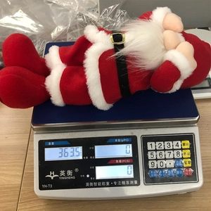 Detail view of the gnome plush decoration on an electronic scale showing weight of 363.5g