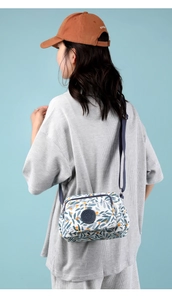 Floral nylon crossbody bag with leaf print and adjustable strap shown on model