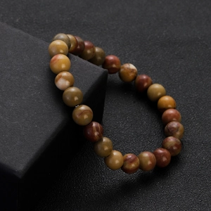 Macro view of multi-color natural chalcedony agate beaded bracelet on a black display box