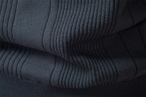 Macro shot of dark blue knit fabric showing vertical rib texture and premium craftsmanship
