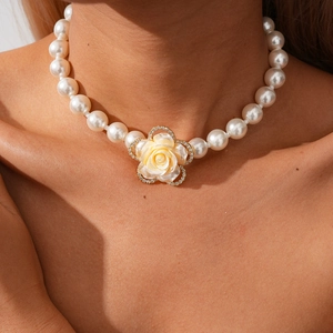 Dettaglio della collana di perle con ciondolo a rosa in resina e piccoli cristalli