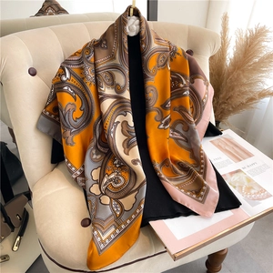 Detail of floral paisley silk scarf draped on a chair with elegant lifestyle decor