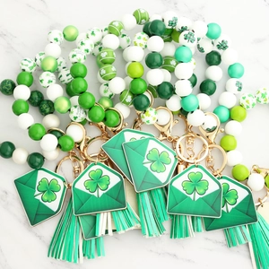 Flat lay of St. Patrick's Day silicone bead keychains with clover charms and green tassels