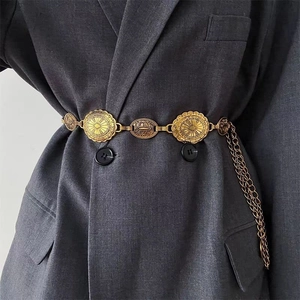 Detail of bohemian gold waist chain with vintage sun embossed discs on a blazer
