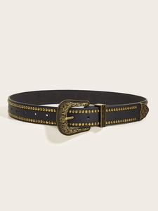 Dettaglio cintura in pelle nera stile western con borchie dorate e fibbia incisa
