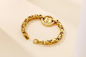 Macro shot of gold hip hop chain with a crystal encrusted couple pendant on steps