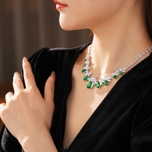 Gros plan du collier avec zircon vert en forme de goutte et accents floraux sur un modèle