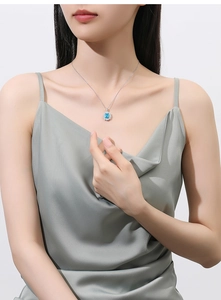 Detail of S925 silver necklace with 2.5ct oval blue gemstone worn by a model