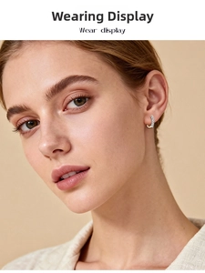 Close-up of elegant U-shape sterling silver earrings with inlaid pavé moissanite on ear