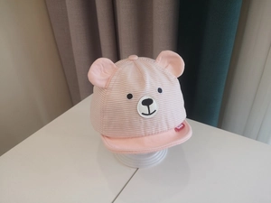 Detail of pink striped baby sun hat with plush 3D bear ears and soft cotton embroidery