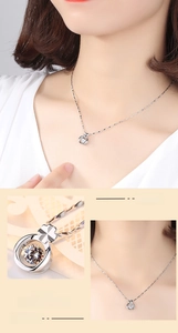 Détail macro d'un pendentif trèfle en argent avec une pierre centrale étincelante et polie