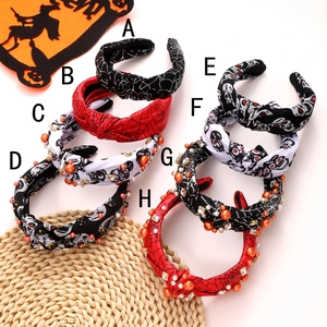 Multiple Halloween knotted headbands with rhinestones, beads, skulls, and spider web patterns