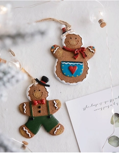 Festive resin gingerbread man ornaments on a rustic table with warm Christmas string lights