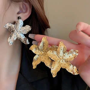 Detailed macro view showing the textured surface of gold and silver fan flower earrings