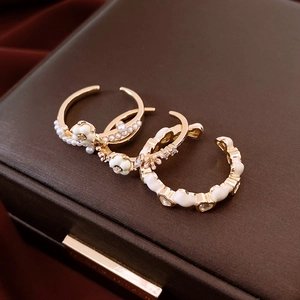 Detail of 14K gold plated rings with enamel flower, heart, and pearl accents