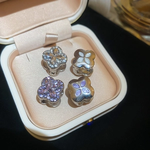 Detailed macro shot of four sparkling clover charms in a luxury jewelry display box