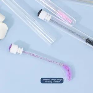 Close-up of flexible spiral eyelash brushes with glitter handles and protective tubes