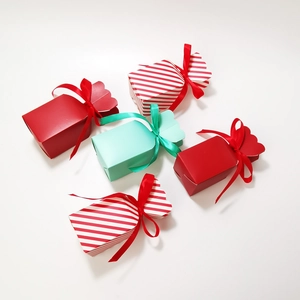 Red stripe and solid candy-shaped gift boxes with ribbons for Christmas and weddings