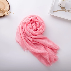Detail view of pink cotton linen scarf featuring natural crinkle texture and frayed edges