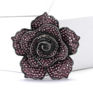 Macro shot of rose brooch with purple rhinestones on a high-end vintage metal base