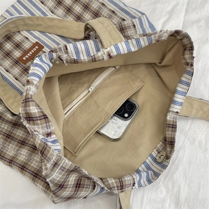 Close-up of canvas tote bag interior showing khaki lining and inner zipper pocket