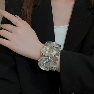 Detailed view of wide silver wired bracelet with large spiral decorative elements