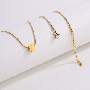 Macro shot of gold floral pendant necklace featuring sleek snake chain and lobster clasp