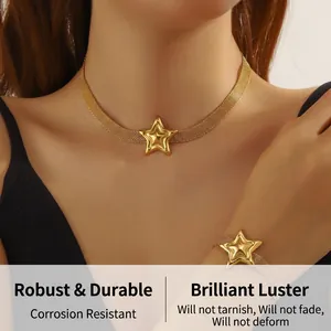 Detailaufnahme einer vergoldeten Mesh-Halskette und eines Armbands mit Sternanhängern am Model