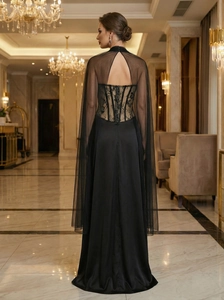 Detailed back view of black lace evening gown featuring a sheer bodice and mesh cape