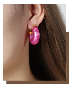 Close-up of elegant rose red marble resin U-shaped hoop earring on model's ear