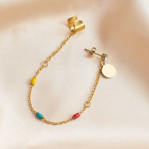 Detail of gold ear cuff and stud set with colorful enamel beads on a chain