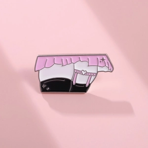 Détail d'un pin's en émail de style anime avec un motif de jarretière à cœur rose