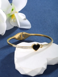 Detail of gold-plated heart bracelet with black center and sparkling pavé crystals