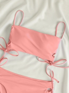 Detail of pink two-piece bikini featuring stylish side ties and adjustable shoulder straps