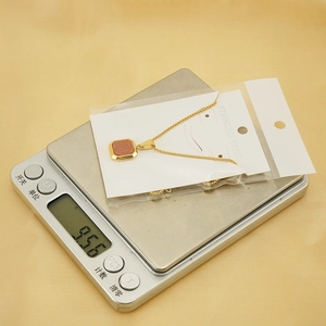 Détail d'un collier en acier inoxydable plaqué or 18K pesant 9,56g sur une balance précise