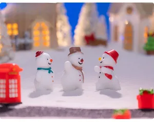 Detailed view of three cute miniature resin snowmen in a winter DIY snow scene setting