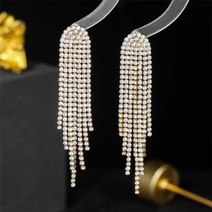 Macro shot of long gold tassel earrings with multi-row sparkling crystal rhinestones