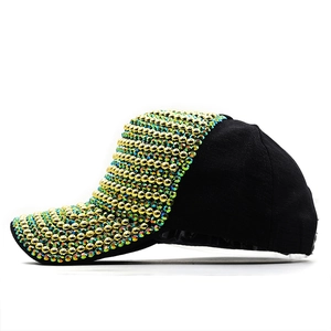 Detail of luxury black baseball cap featuring dense gold and iridescent rhinestone accents