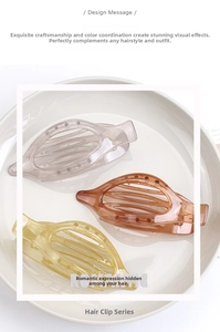 Close-up of three translucent oval hair clips in lavender and amber on a ceramic tray