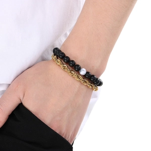 Close-up of men's beaded bracelet set with black matte beads and gold rope chain