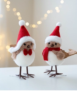 Detail view of plush Christmas birds with red Santa hats and scarves for festive decor