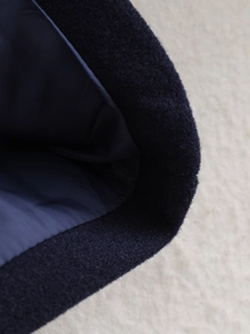 Close-up of wool fabric texture and smooth lining of the navy blue short coat