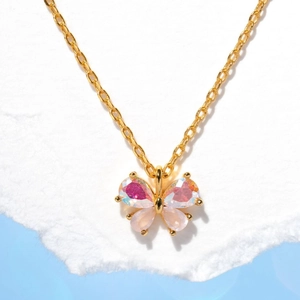 Close-up of gold butterfly necklace pendant with iridescent crystal and cat eye stone