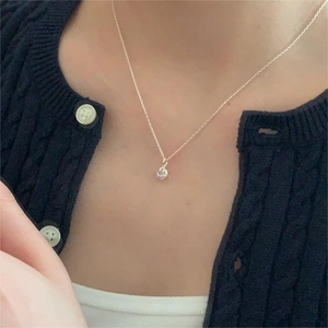 Close-up of 925 sterling silver chain necklace with a circular hollow pendant on model